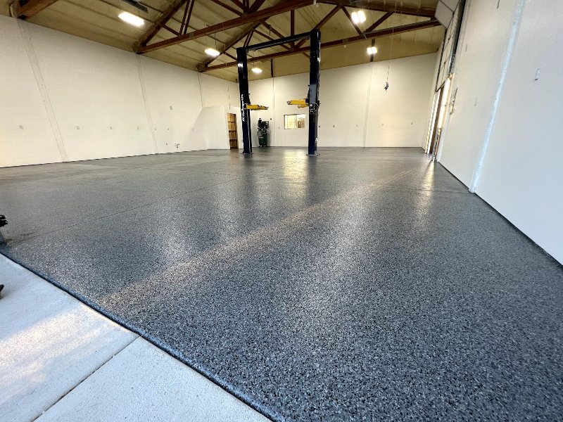 Dark commercial warehouse epoxy floor with a finished coating