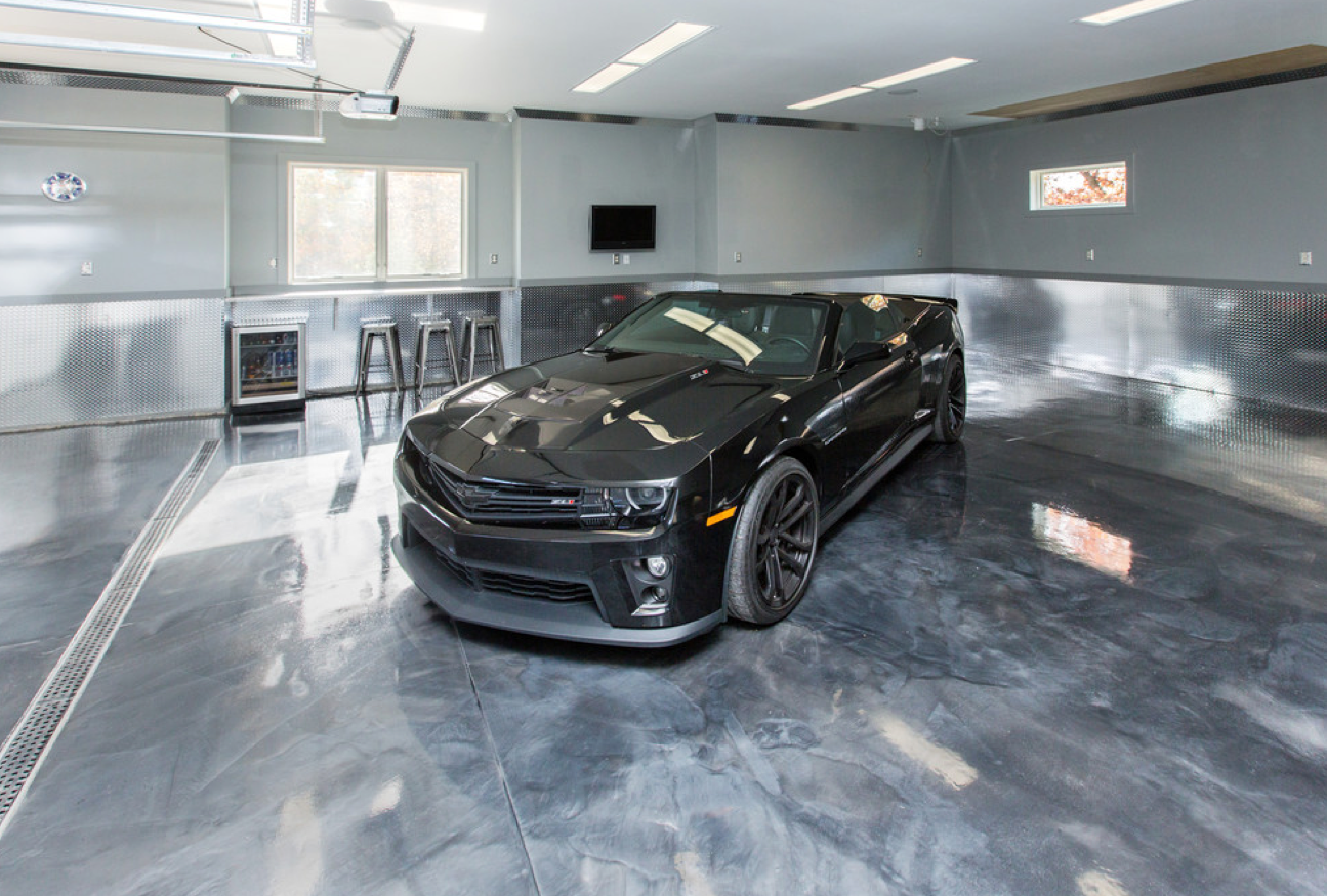 Black metallic epoxy garage floor with a black car parked inside