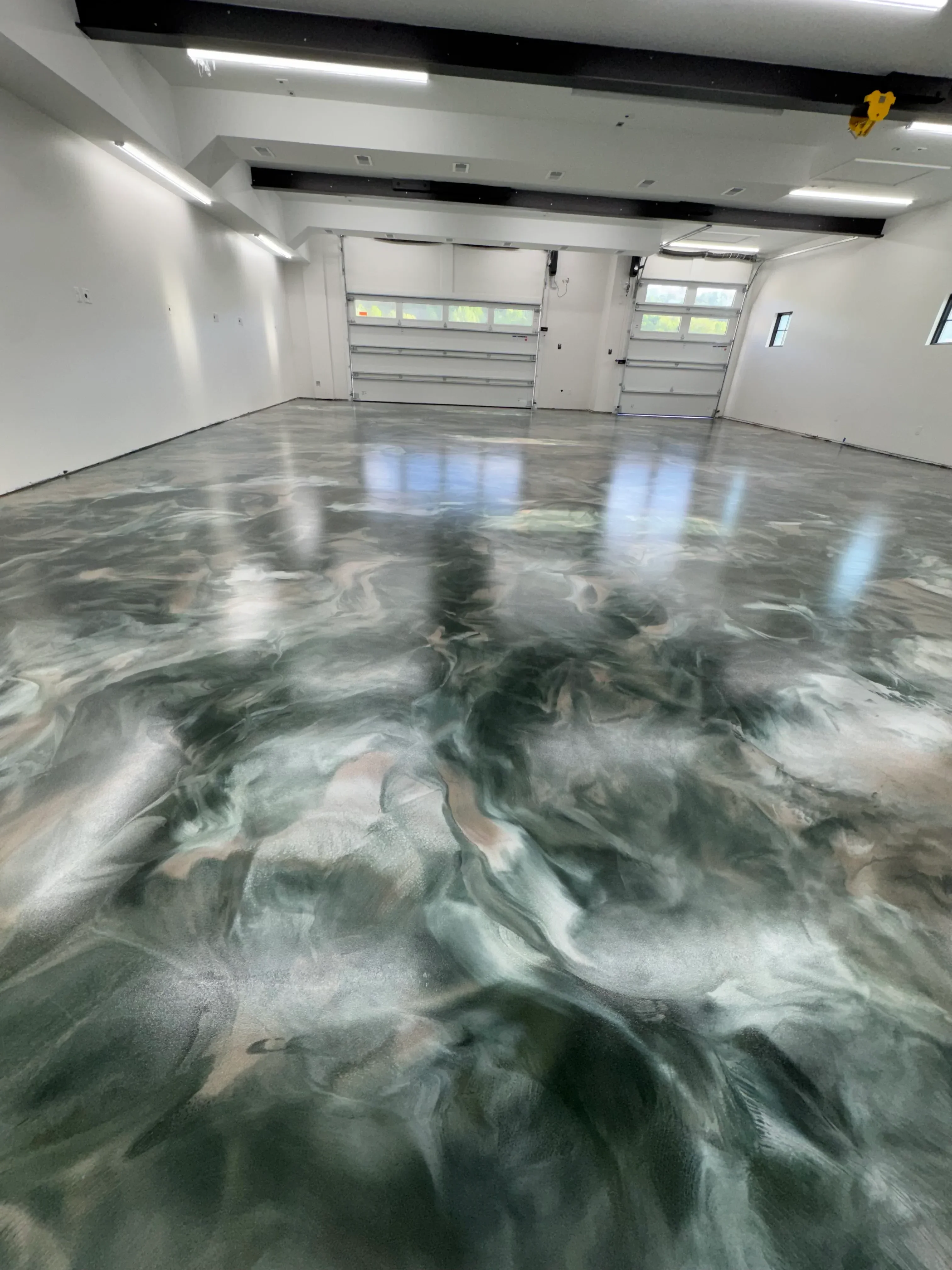 Polished concrete hallway with gray swirled finish, reflective surface, and natural light