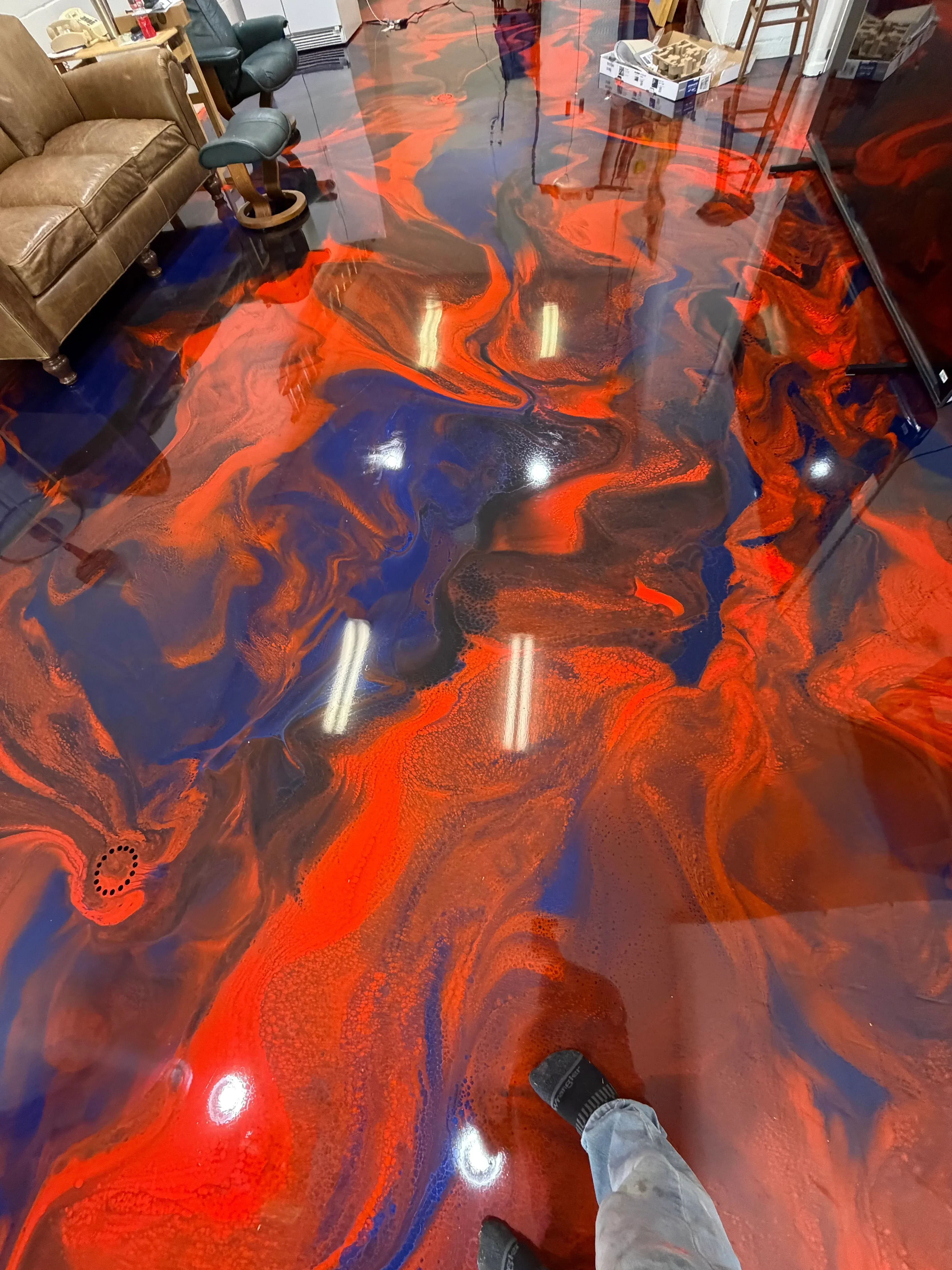 Orange and blue swirled epoxy floor with high-gloss finish and recessed lighting