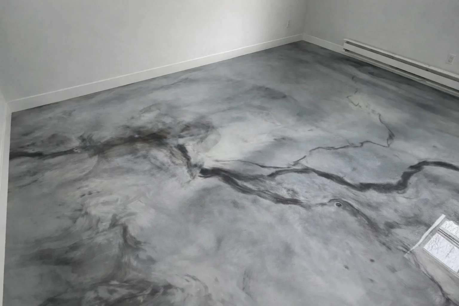 Gray marble-effect epoxy floor coating with dark veining on concrete subfloor