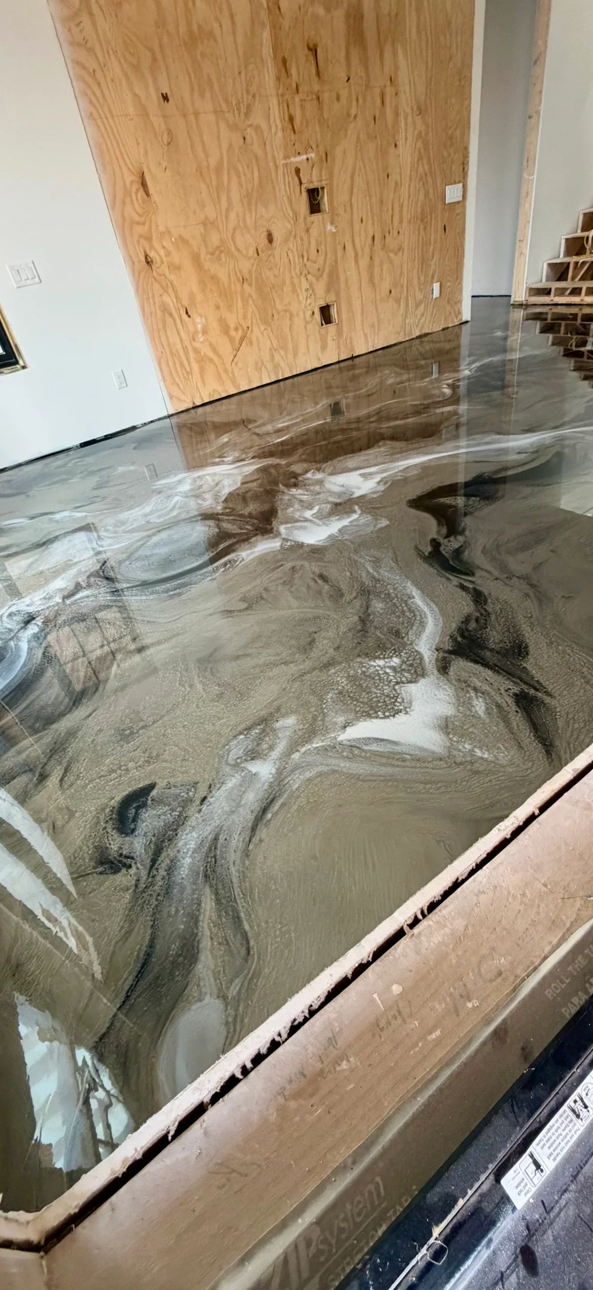 Metallic epoxy floor with gray and white swirled patterns and glossy finish in commercial space