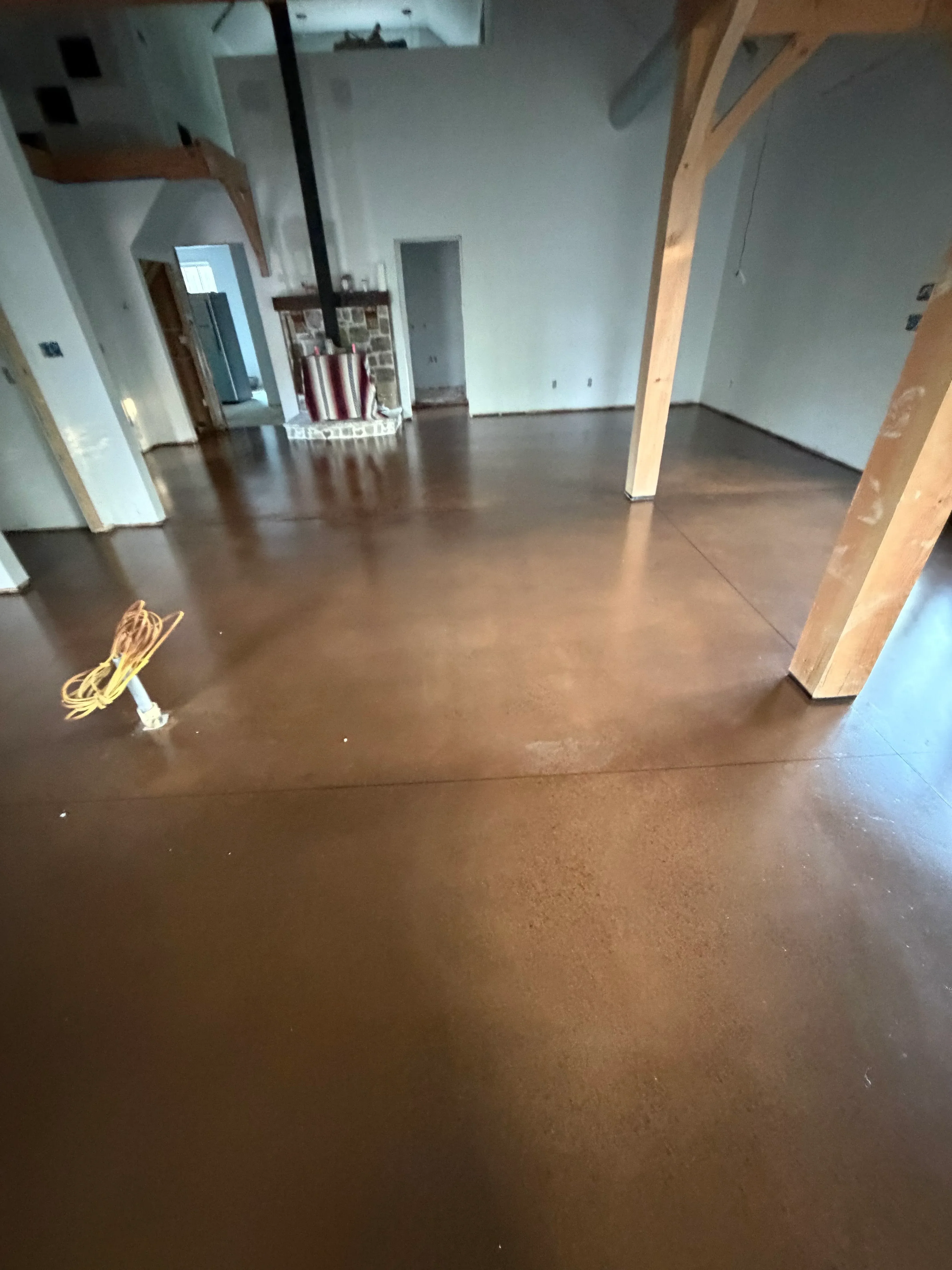 Brown metallic epoxy floor coating with wood trim and electrical installation in progress