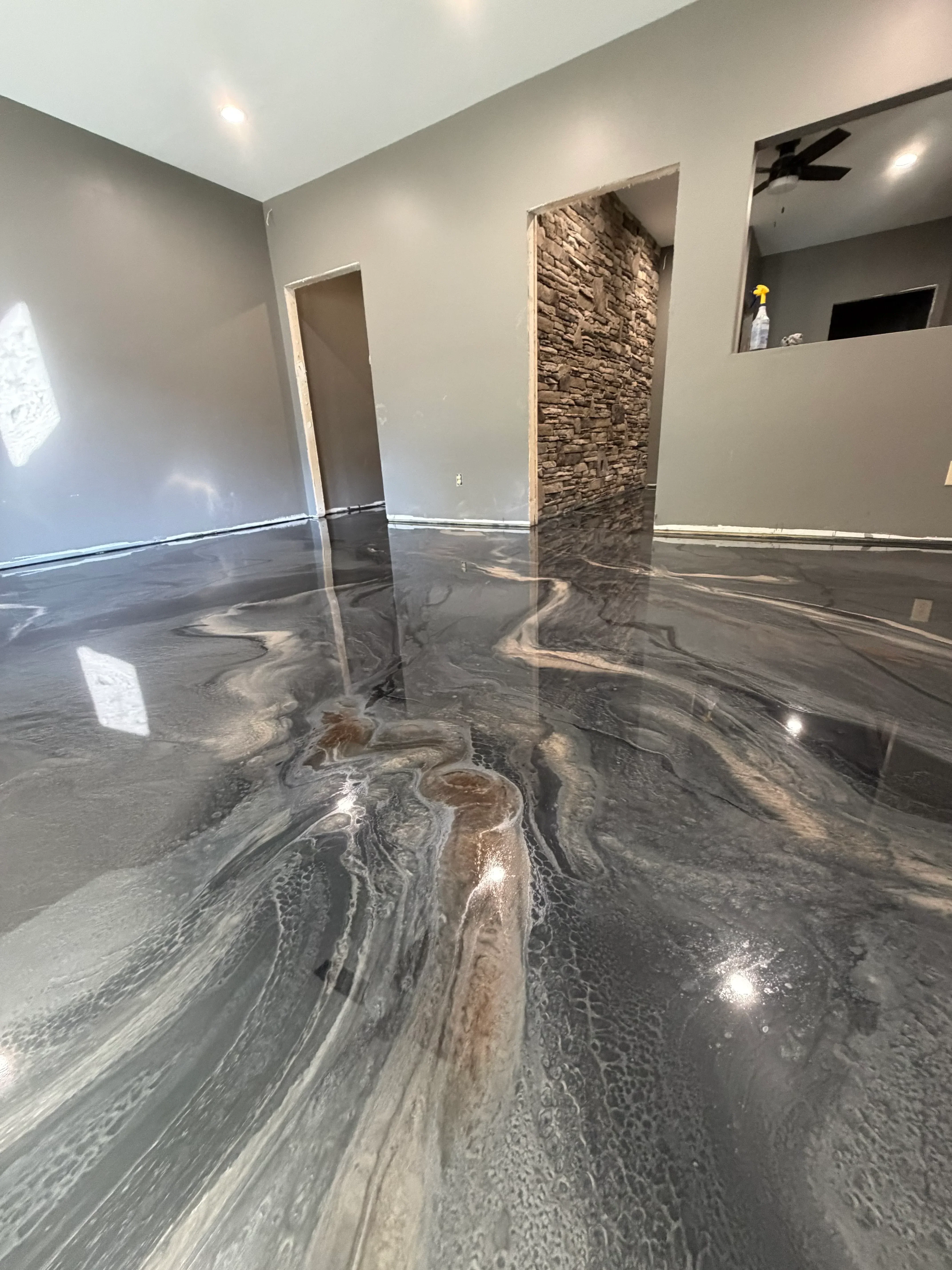 Polished concrete floor with gray marble epoxy finish, wood-grain accent strip, and recessed lighting