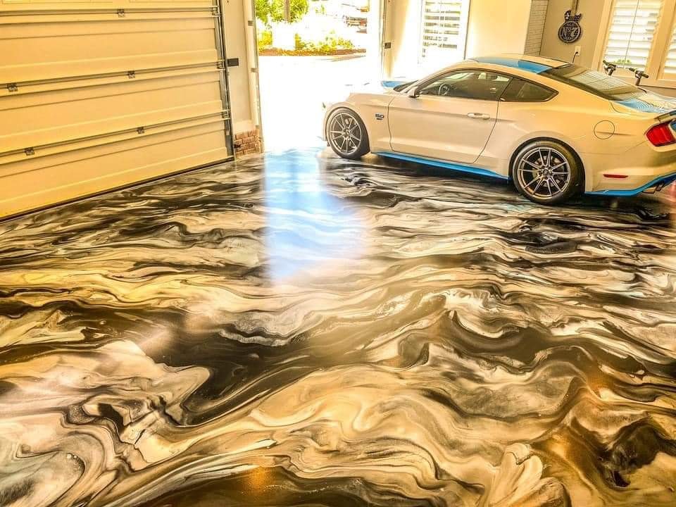 Black and gold metallic epoxy garage floor with a white sports car